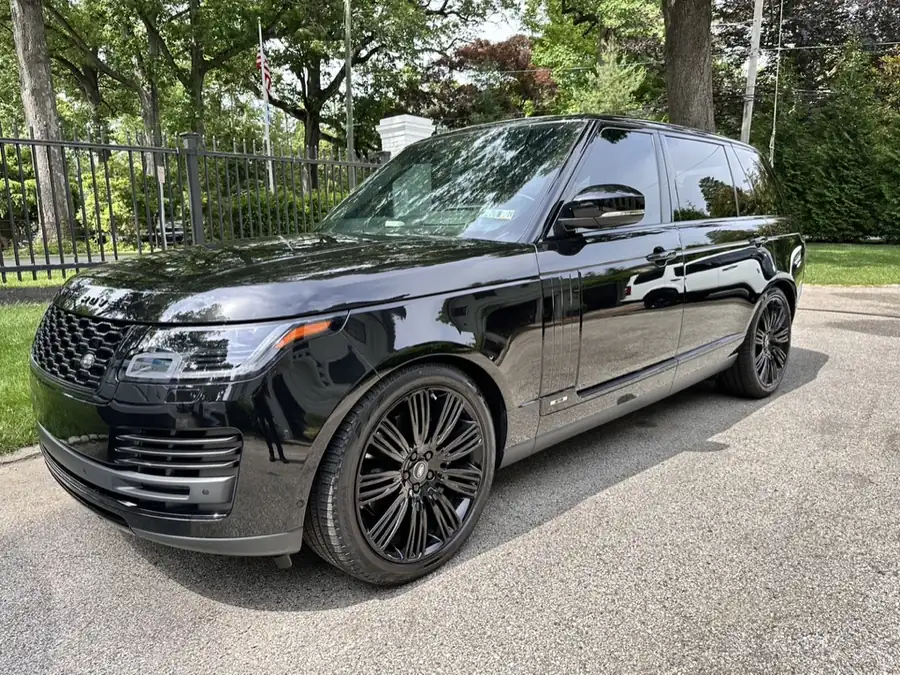 Black Range Rover after a full detail, parked on a tree-lined drive