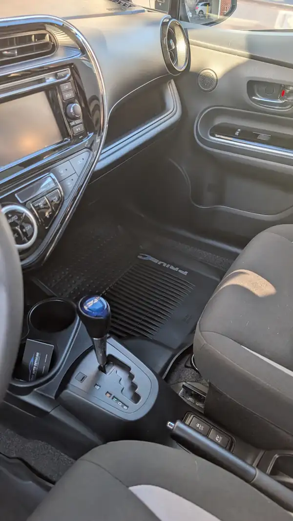 Toyota Prius C cabin after an interior clean, a Pro Auto Detailing card in the cup holder